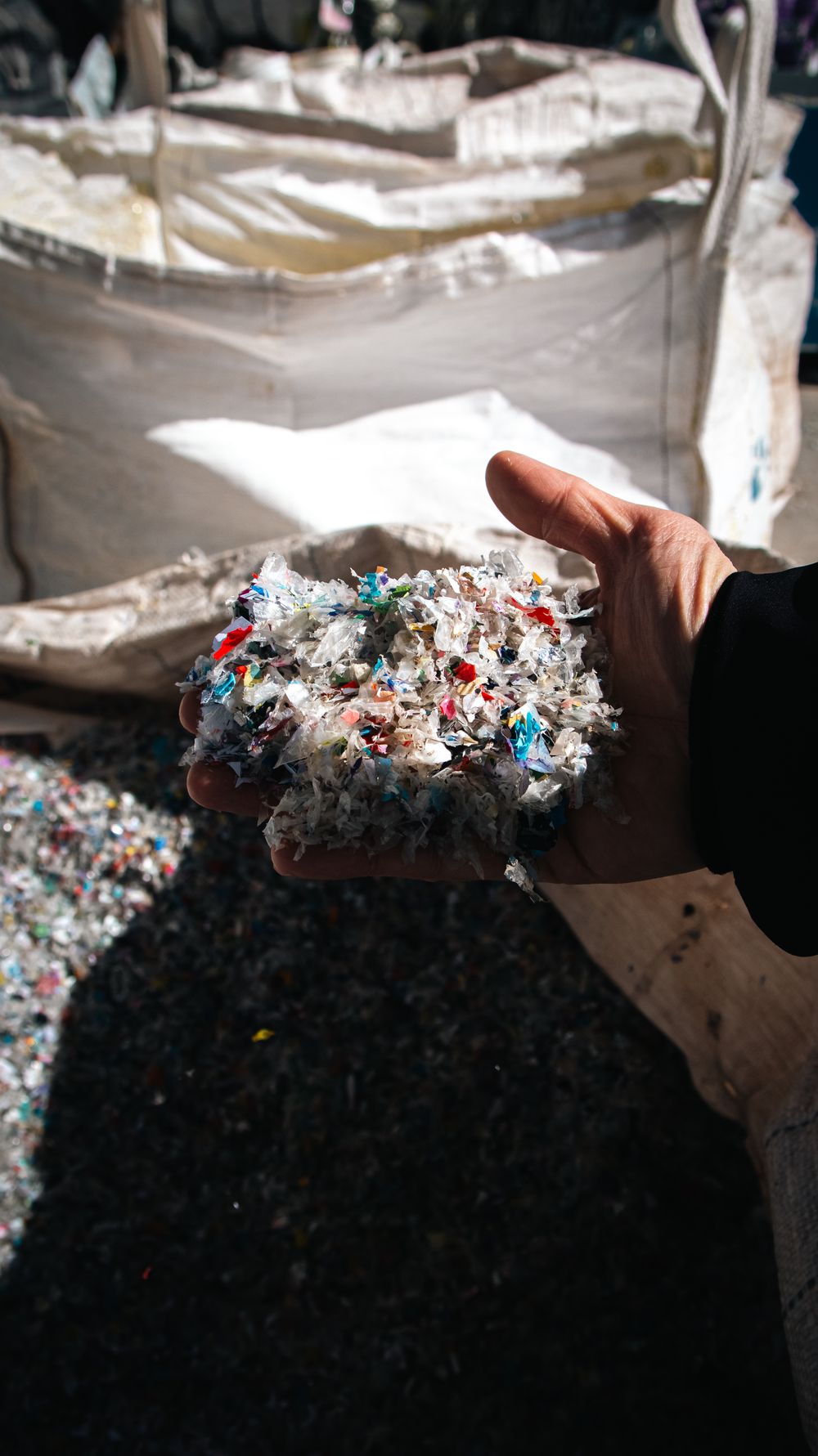 A handful of shredded recycled PET flakes at an EcoTribe sorting facility